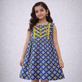 Young girl wearing a blue and yellow patterned dress on a plain background