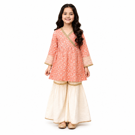Little girl wearing a peach printed kurta gharara suit with gold lace detailing by Tiny Soul
